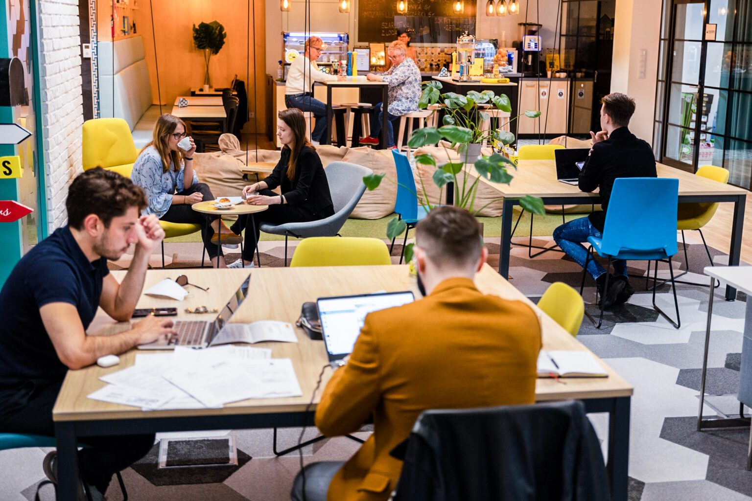 Osoby pracujące przy wspólnych biurkach w coworkingu Workin